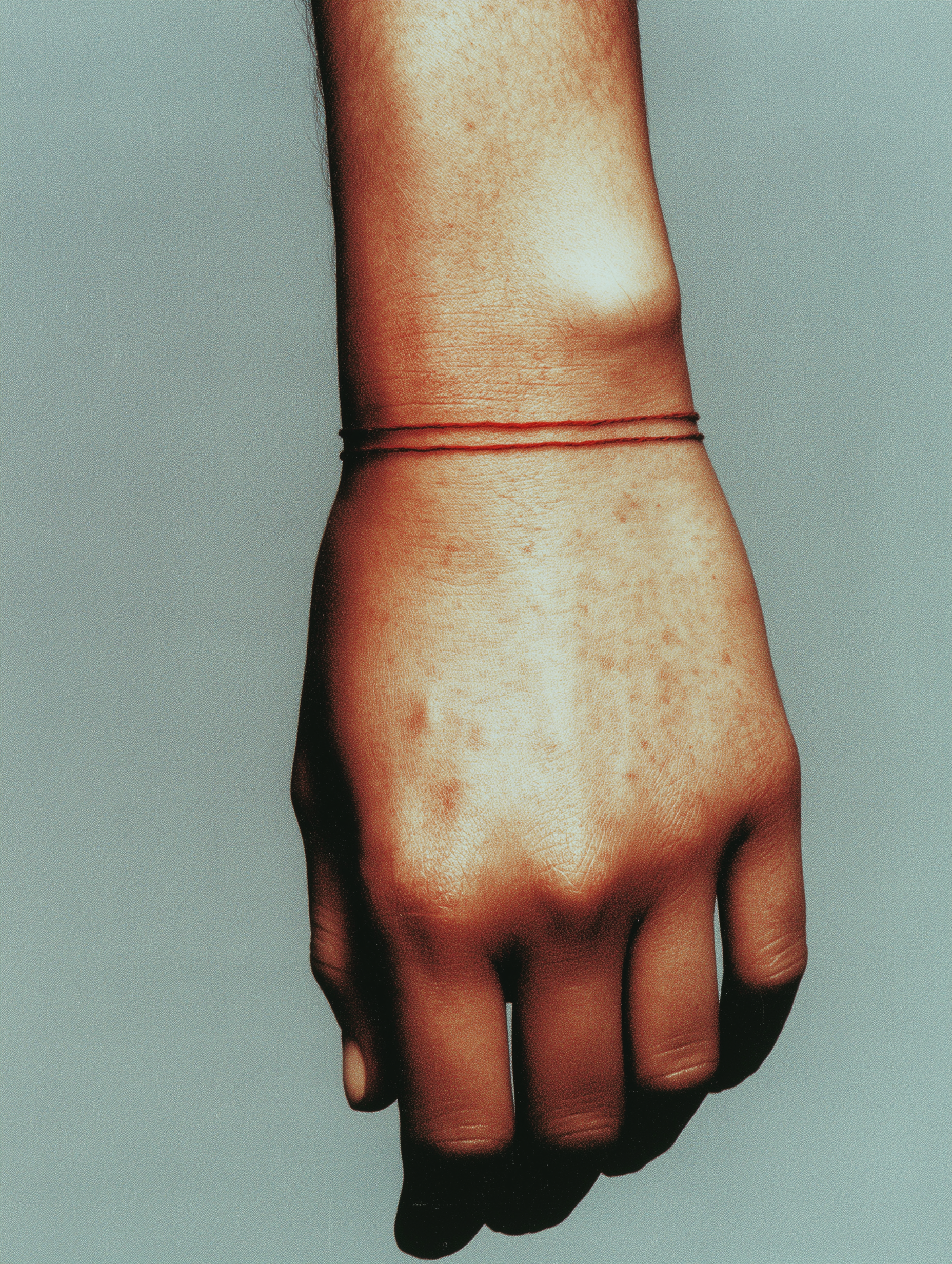 Hand with a bracelet on a plain background